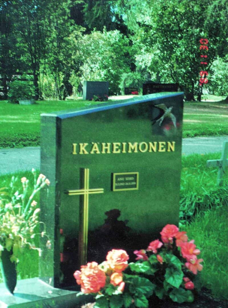 hautakivi-15-varpaisjarven-musta | Kivilevander Hautakivi Aalto on musta hautakivi, jonka yläosa on vinon mallinen. Kiven vasemmassa alaosassa on risti ja oikealla ylhäällä lintu. Ylhäällä keskellä on teksti.