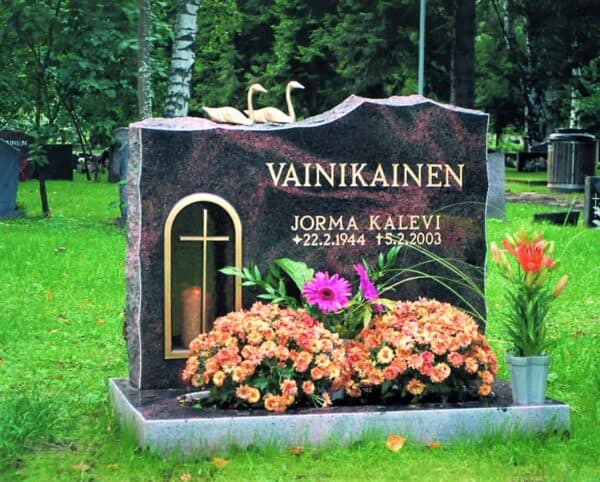 Hautakivi Vainikainen on musta hautakivi, jossa menee punertavia kuviointeja. Hautakiven vasemmassa reunassa on kullattu syvennys kynttilälle ja sen lasisessa ovessa on risti.