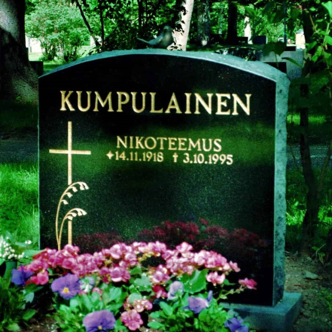 Hautakivi Kumpulainen on musta hautakivi, jonka vasemmassa reunassa on risti ja kaksi heinää pronssisena.