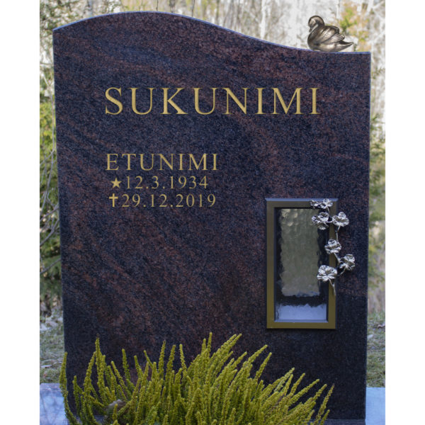 Kuvassa on hautakivi Muratti, joka on väritykseltään musta muutoin, paitsi siinä kulkee ympäriinsä punertavaa halkeama kuviointia. Hautakivessä on oikealla kynttilälle tarkoitettu syvennys.